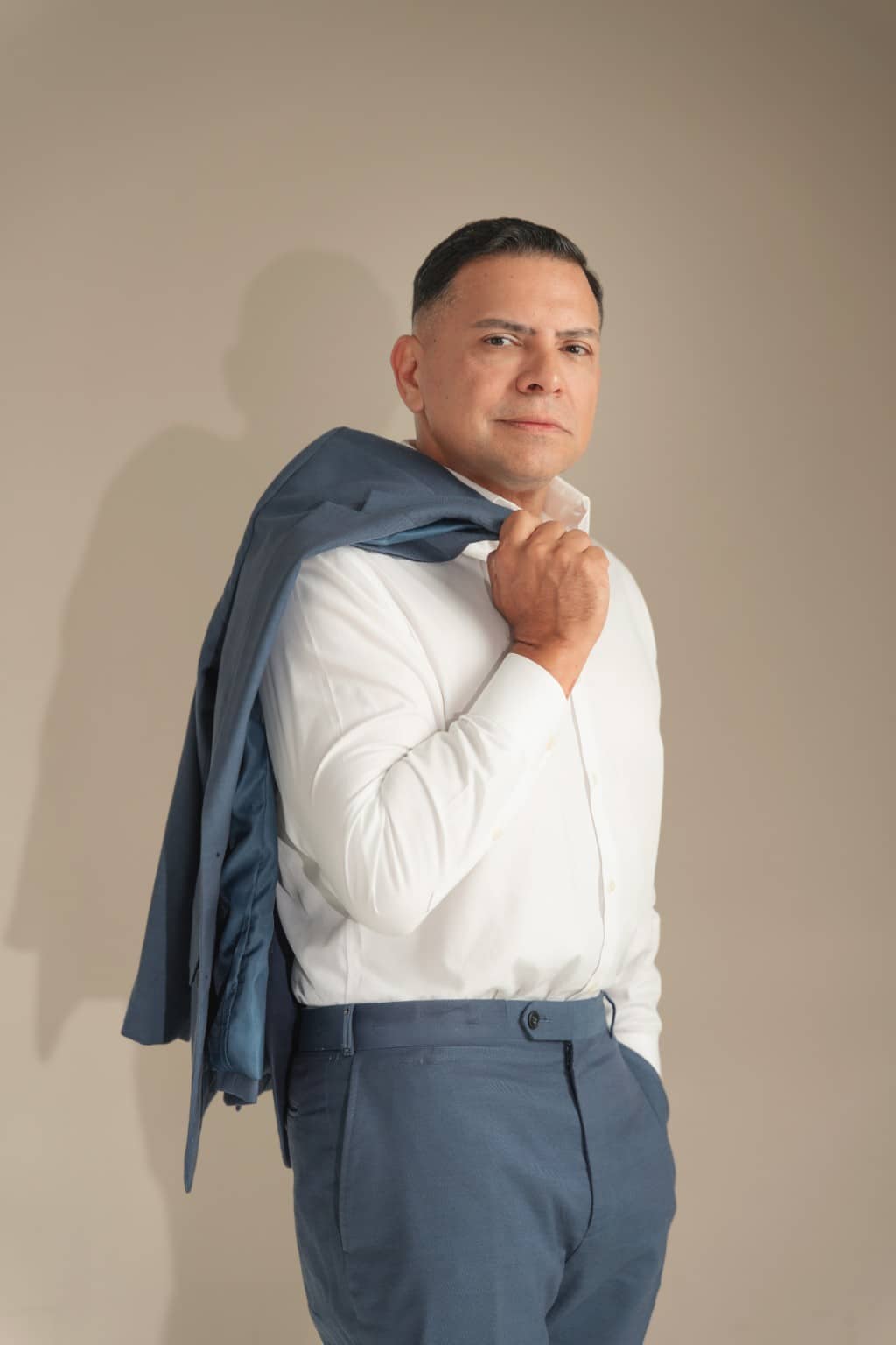 Attorney José O. Castañeda, Jr. in a white shirt with his jacket over one shoulder