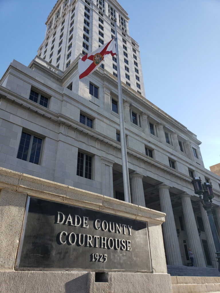 The facade, plaque and Florida state flag of the historic Miami-Dade County Courthouse in downtown Miami.