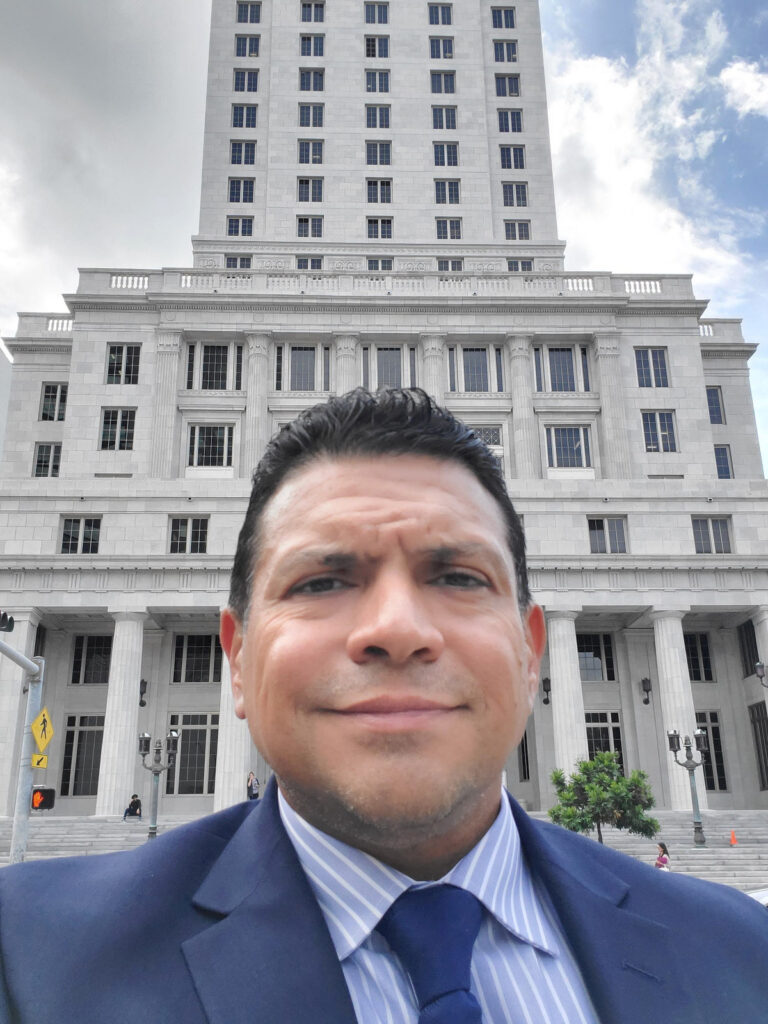 José O. Castañeda, Jr. of Castaneda Law Group in a street portrait with the historic Miami-Dade County Courthouse behind him.