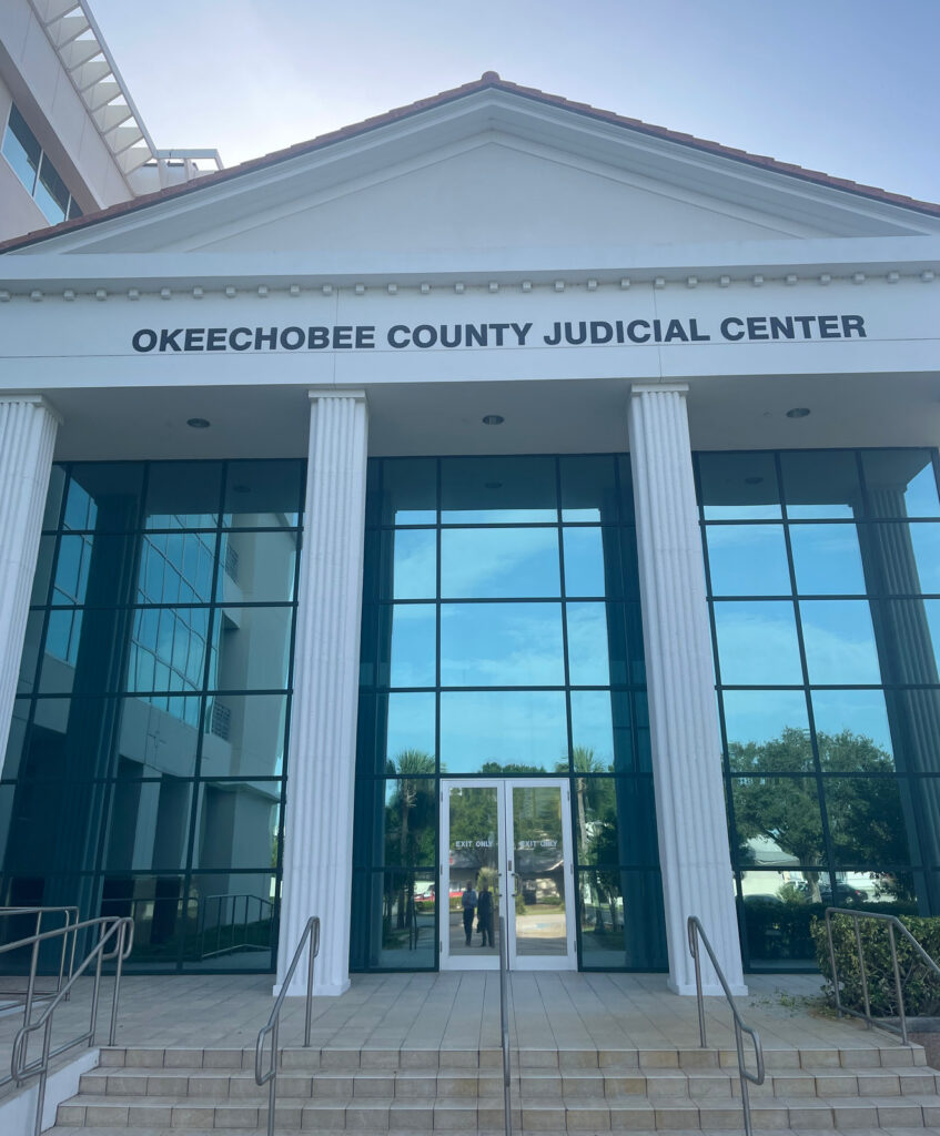 The entrance and sign of the Okeechobee County Judicial Center in Okeechobee, Florida.