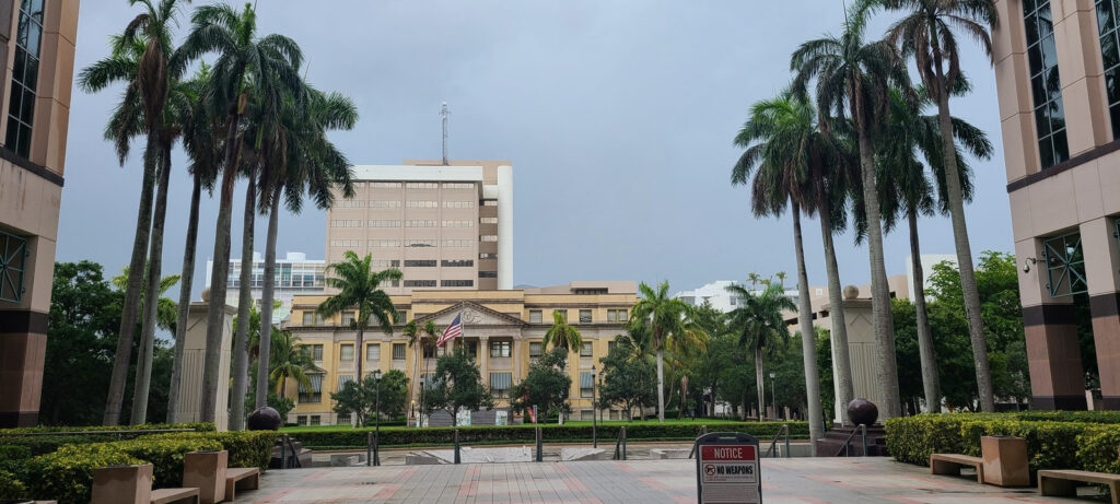A view toward the 1916 Palm Beach County Courthouse through a palm-lined courtyard in West Palm Beach, Florida.