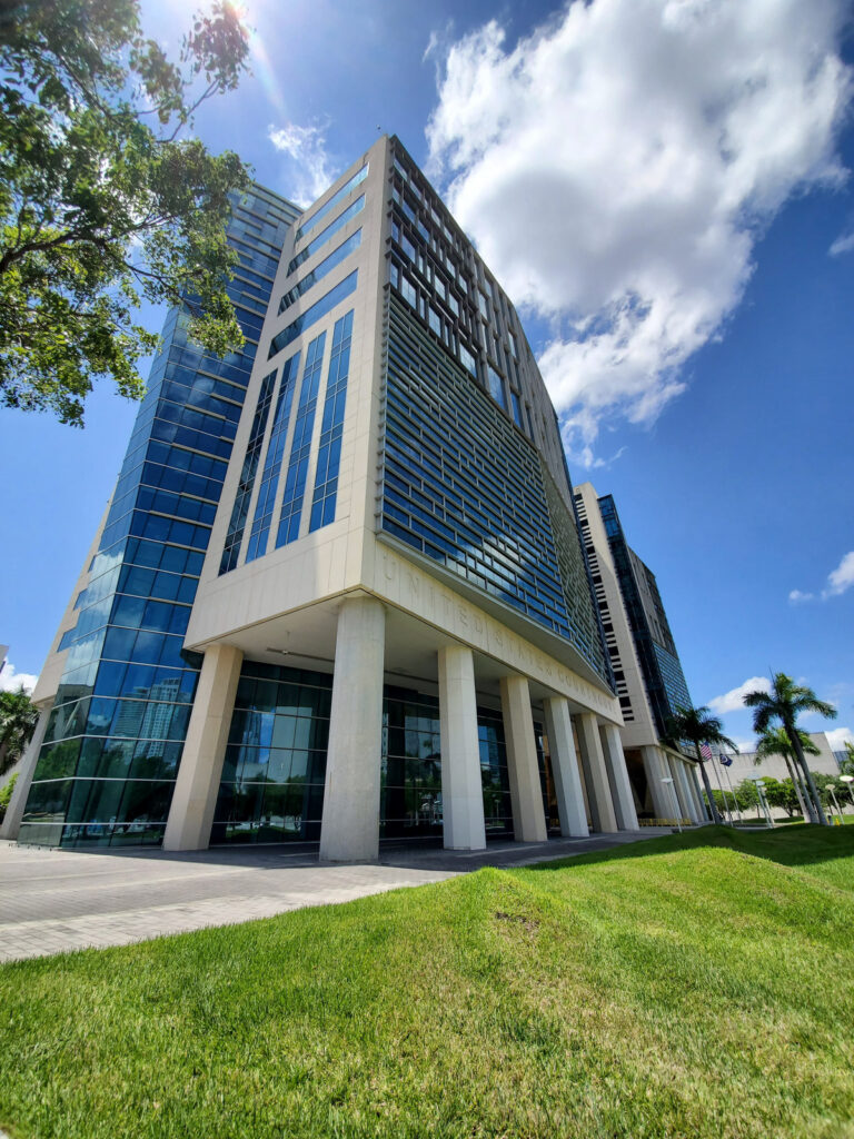 An angled view of the glass facade and columns of the Wilkie D. Ferguson, Jr. U.S. Courthouse in downtown Miami, Florida.
